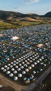 Vista aerea di un campeggio festival con centinaia di tende tra le colline